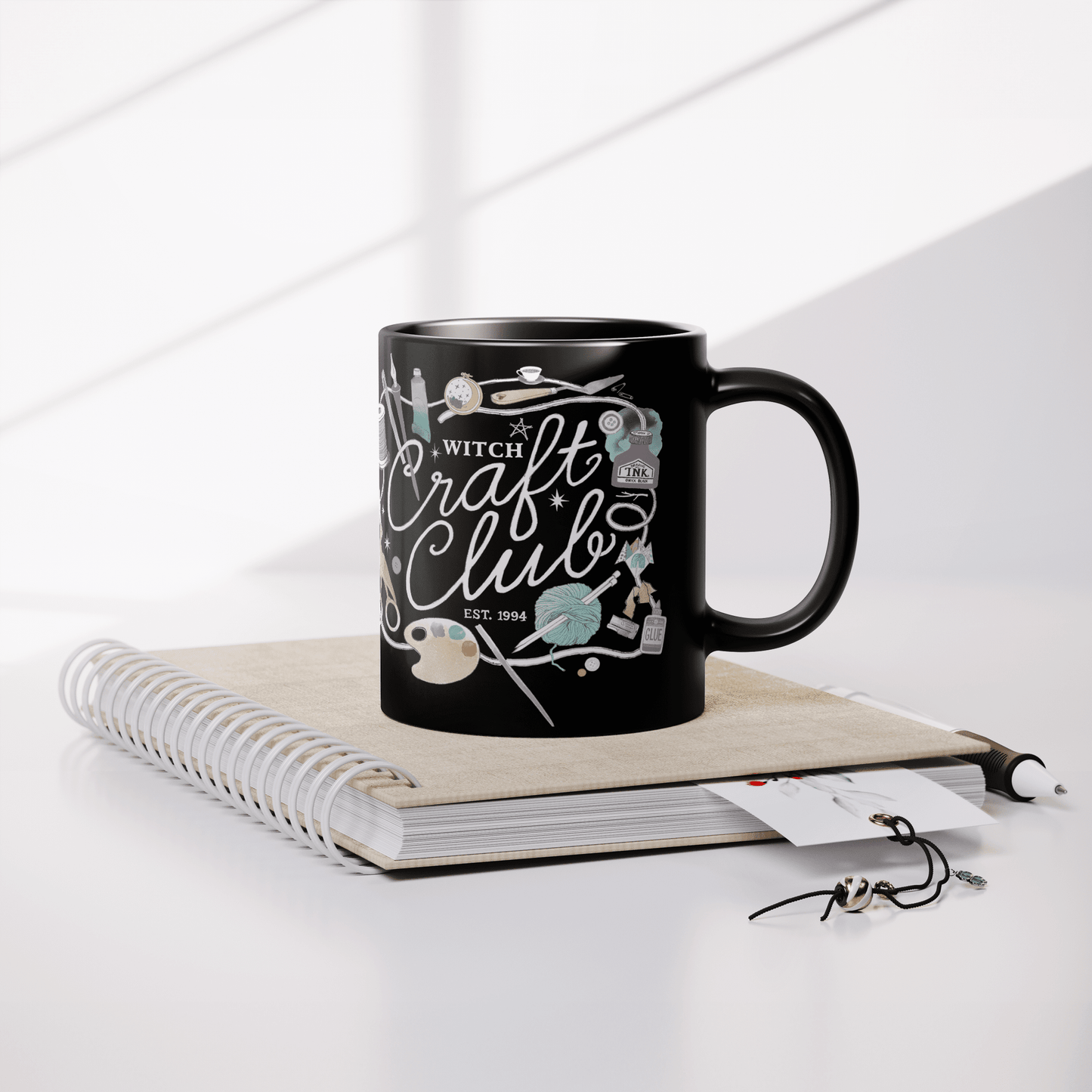 Witch_Craft_Club_-_11oz_Black_Mug_Lifestyle_Notebook_Mockup.png